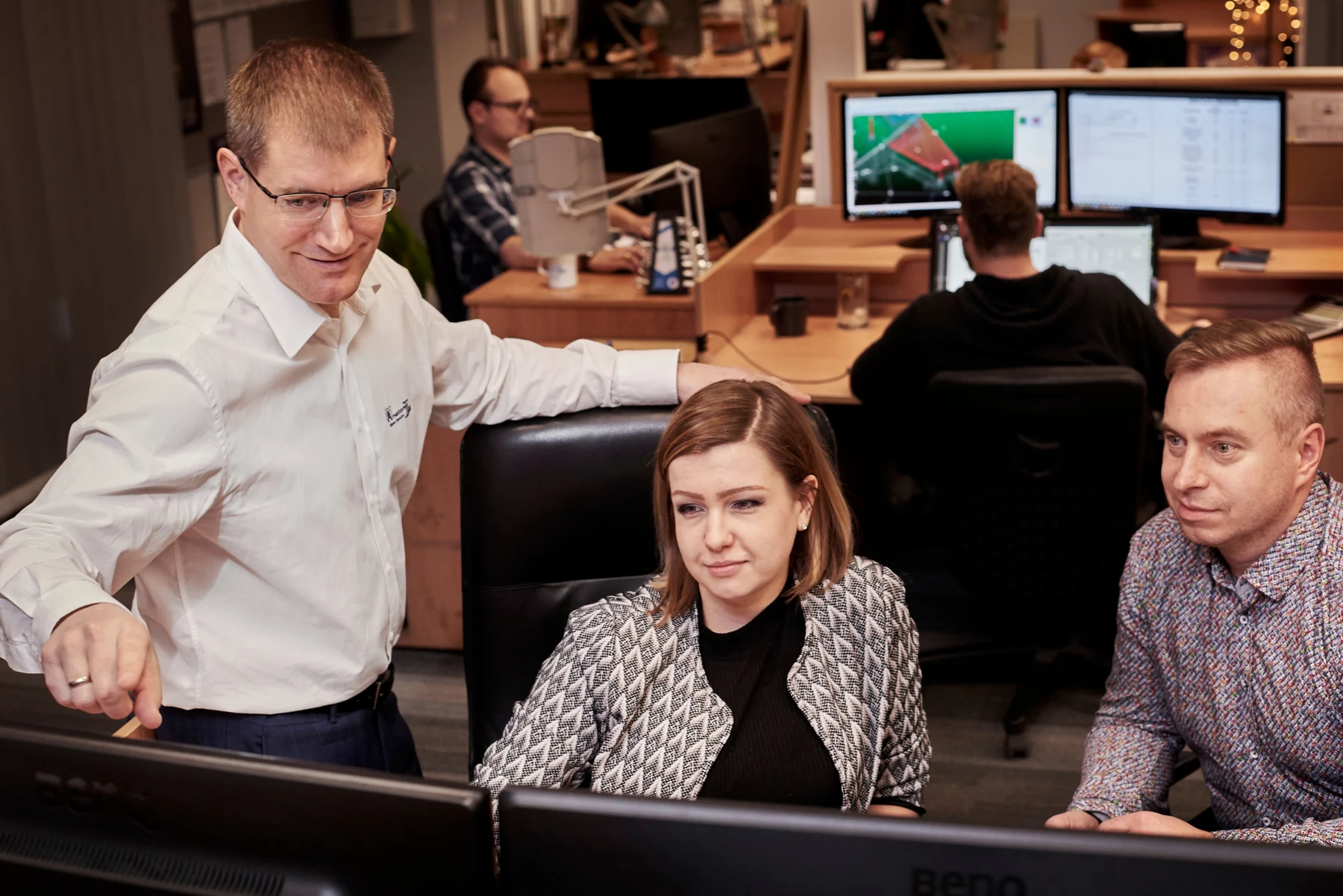 Anatomic instructor reviewing a model with colleagues at an office workstation
